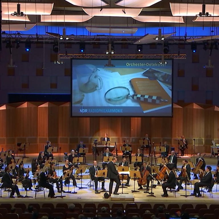 Orchester-Detektive: Das verlorene Menuett – W. A. Mozart und seine Prager Sinfonie. Kinderkonzert mit Malte Arkona · Orchester-Detektive