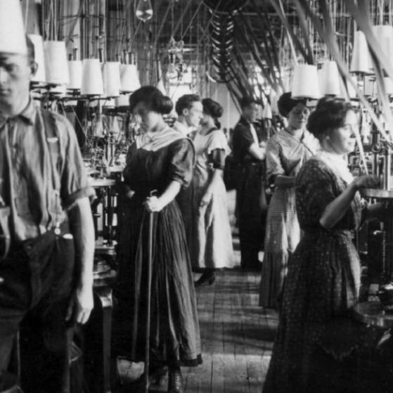 Archivbild Männer und Frauen arbeiten an Spulen in einer Textilfabrik