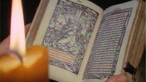 Eine Kerze vor einem mittelalterlichen Buch