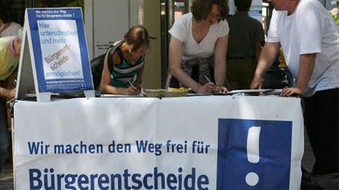 an einem Stand werden Unterschriften gesammelt (Foto: dpa)