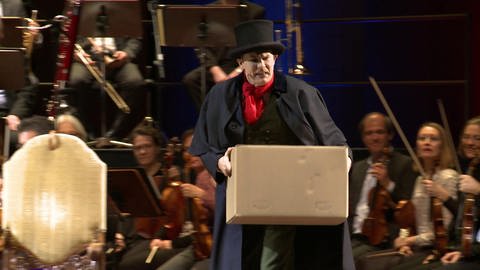 Moderator Malte Arkona mit Umzugskartons auf der Bühne.