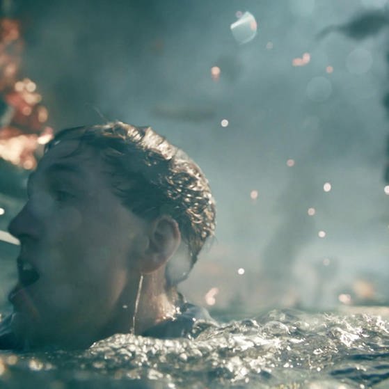 Filmszene: Jan Krauter als Matrose taucht zwischen brennenden Schiffen auf.