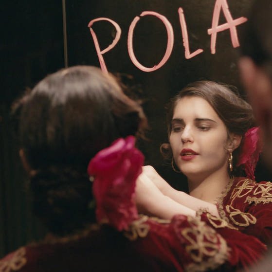 Filmszene: Michalina Olszanska schreibt mit Lippenstift POLA an einen Spiegel.