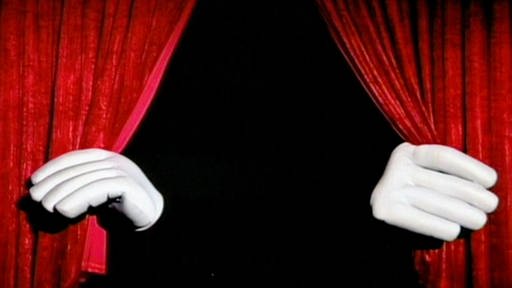 Zwei Riesenhände öffnen einen Theatervorhang