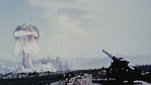 Test einer nuklearen Artilleriegranate in Nevada: Atompilz links im Hintergrund; Geschütz rechts im Vordergrund (Foto: SWR - Screenshot aus der Sendung)