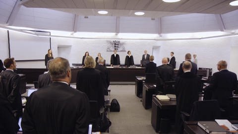 Gerichtssaal mit Zuschauern und Richterbank.
