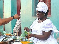 Schwarze Frau verkauft Essen auf der Straße