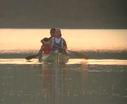 Eine Familie mit Paddelboot auf einem See [Klick auf das Bild, schließt das Fenster]
