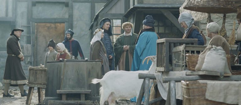 Nachgestellte Szene: Menschen im Mittelalter auf einem Markt