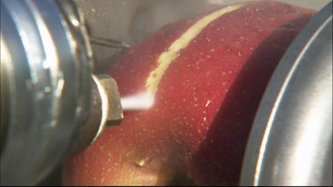 Ein Wasserstrahl zerschneidet einen Apfel. (Foto: SWR - Screenshot aus der Sendung)