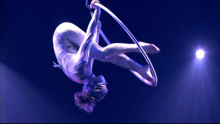 Eine Akrobatin tanzt in einem Luftring.
