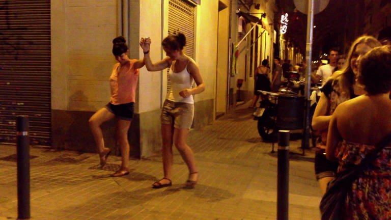 Barcelona bei Nacht: Menschen tanzen auf der Straße.