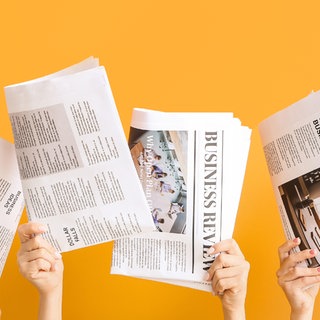 Zeitungen werden in die Höhe gehalten