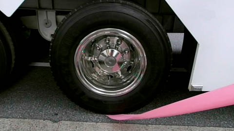 Rosa Schal unter einem Lkw-Reifen. (Foto: SWR – Screenshot aus der Sendung)