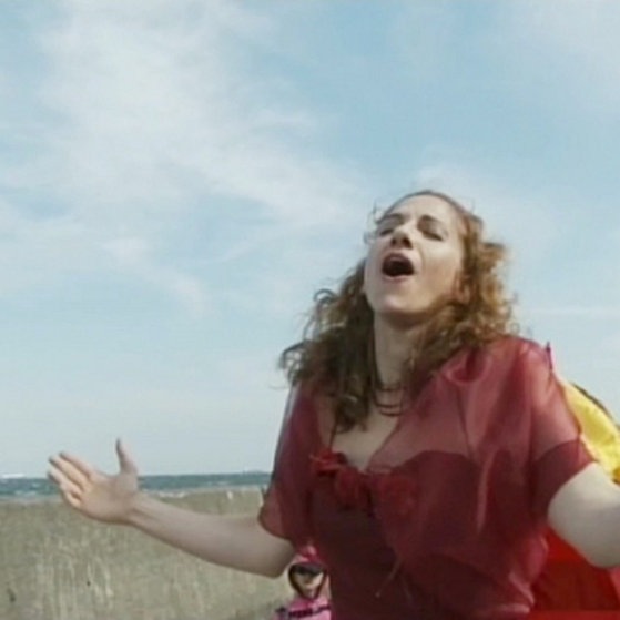 Frau steht auf einer Straße und singt.