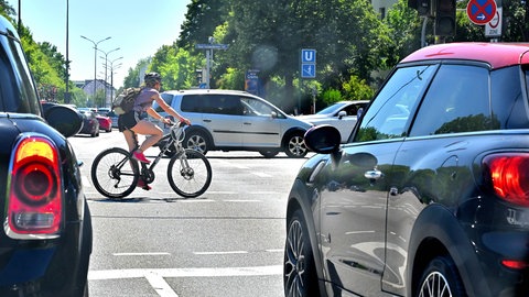 Ein Radfahrer auf einer Kreuzung zwischen Autos. (Foto: IMAGO/Rolf Poss)