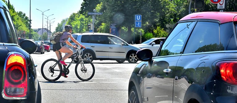 Ein Radfahrer auf einer Kreuzung zwischen Autos. (Foto: IMAGO/Rolf Poss)