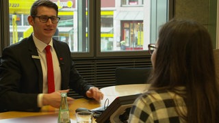 Ein Bankangestellter spricht mit einer Kundin.