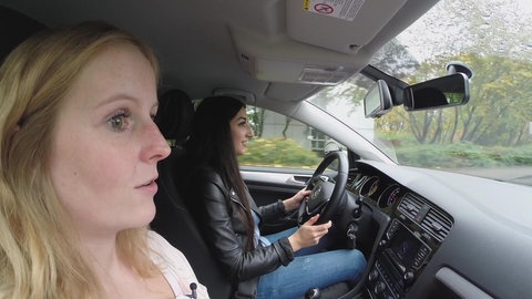 Eine Fahrlehrerin und eine Schülerin im Auto.