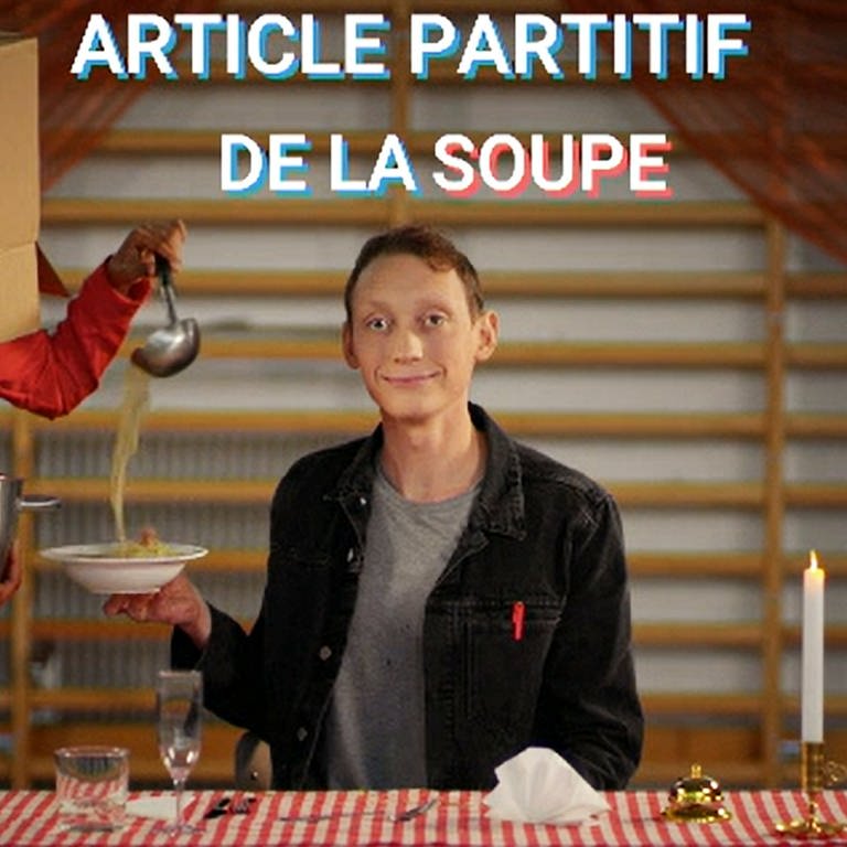 Ein junger Mann bekommt Suppe serviert, über ihm die Einblendung "article partitif - de la soupe"