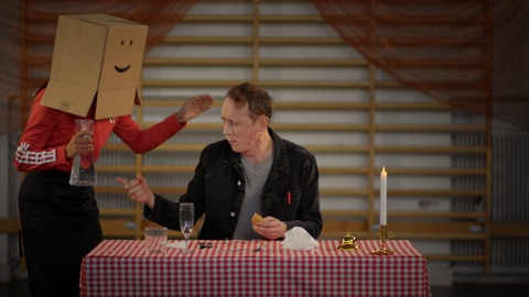 Moderator Jonas bekommt eine Karaffe Wasser angeboten. Wie wird das 