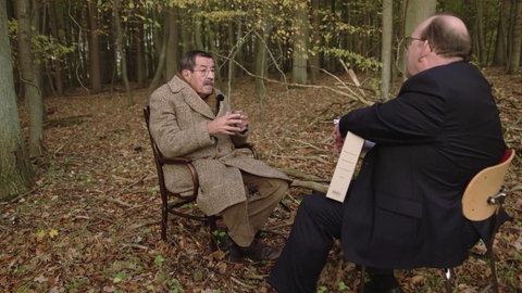 Günter Grass und Dennis Scheck auf Stühlen im Wald.