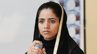 Rapperin und Aktivistin Sonita Alizadeh mit Mikrofon in der Hand