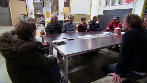 Menschen verschiedenen Alters sitzen um einen großen Tisch. (Foto: SWR – Screenshot aus der Sendung)