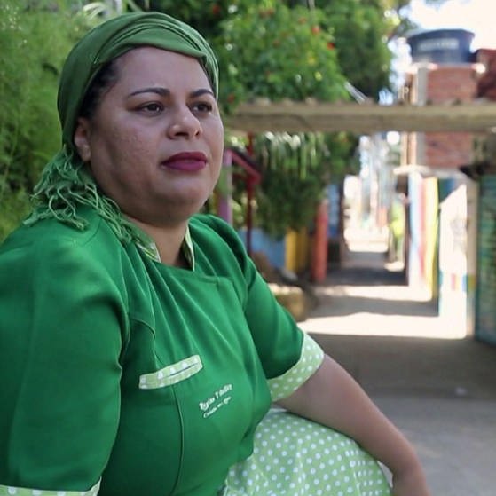 Regina Tchelly in grüner Köchinnen-Kleidung. (Foto: SWR – Screenshot aus dem Film)
