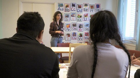 Ein Mädchen steht vor einer Klasse.