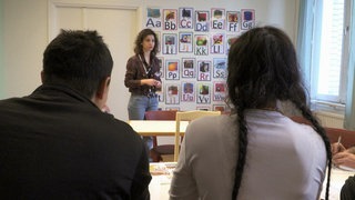 Ein Mädchen steht vor einer Klasse.