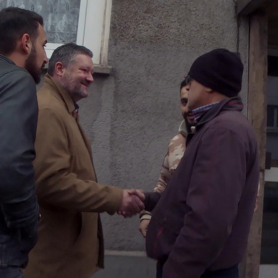 Pater Oliver mit drei Männern auf der Straße.