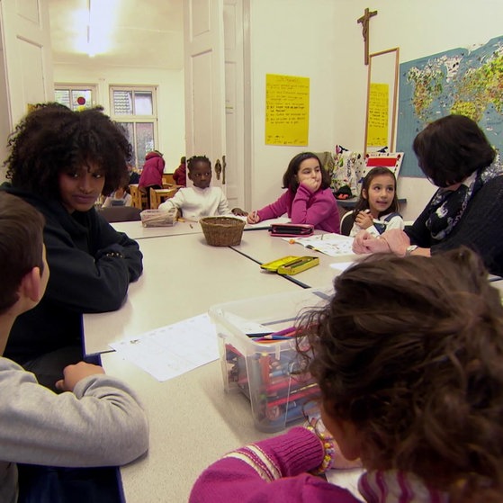 Tezebit mit Kindern an einem großen Tisch. (Foto: SWR – Screenshot aus der Sendung)