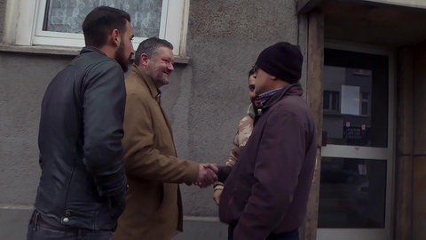 Pater Oliver mit drei Männern auf der Straße.