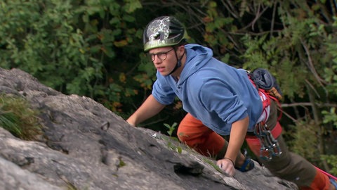 Jonathan beim Klettern an einem Felsen.