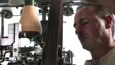Textilfabrikant Rudolf Loder neben alter Spindel