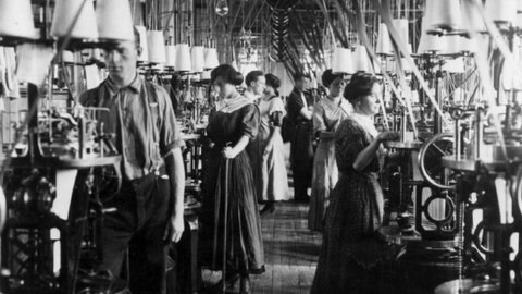 Archivbild Männer und Frauen arbeiten an Spulen in einer Textilfabrik