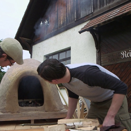 Zwei Männer betrachten Backofen-Nachbau.