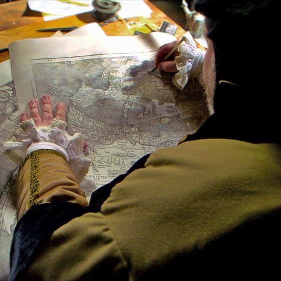 Kartograph bei der Arbeit (Spielszene)