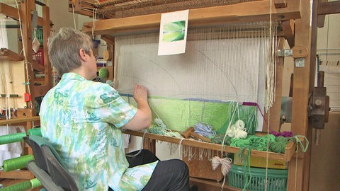 Eine Textilexpertin zeigt die alte Technik des Bildwirkens.