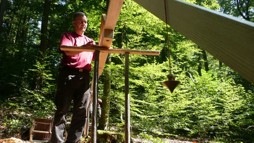 Ein Mann bei der Höhenvermessung mit einem römischen Messaparat.