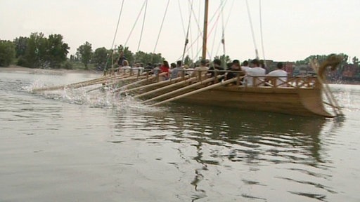 Hölzernes Ruderschiff auf einem Fluss.