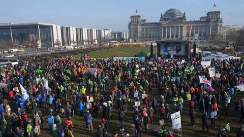 Menschen versammeln sich vor dem Reichstag in Berlin. Wie funktioniert unsere Demokratie? Wie geht Zusammenleben in unserer Gesellschaft?