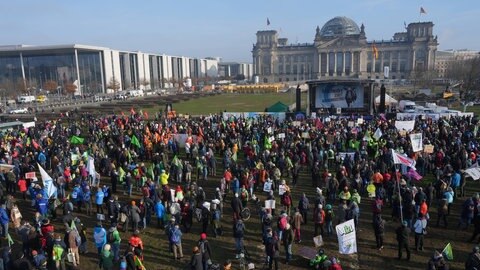 Menschen versammeln sich vor dem Reichstag in Berlin. Wie funktioniert unsere Demokratie? Wie geht Zusammenleben in unserer Gesellschaft?