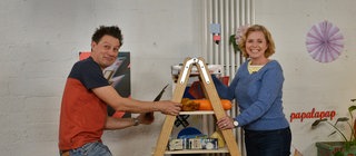 Moderator André Gatzke und die Lehrerin Frau Fobbe stehen an einer Leiter.