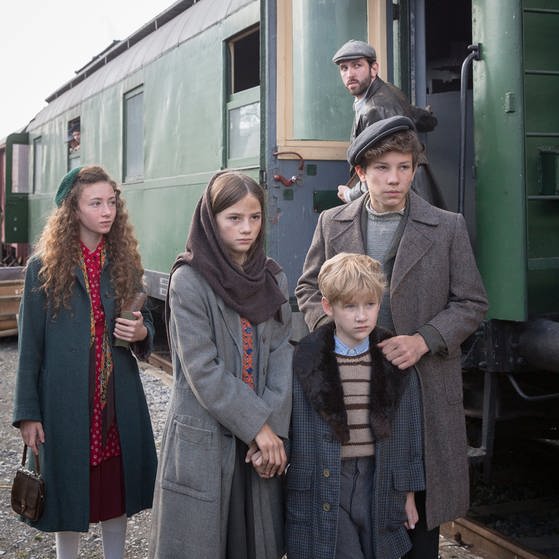 Vier Kinder stehen am Bahnhof neben einem Zug. (Foto: LOOKSfilm/Andreas Wünschirs)