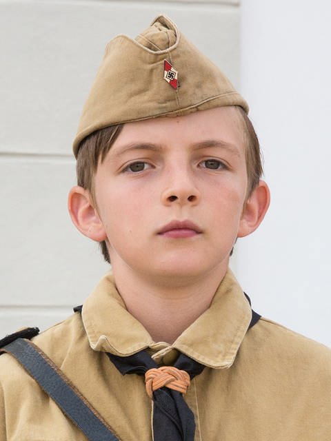 Portrait eines jungen in brauner Uniform mit Hakenkreuz-Abzeichen. (Foto: LOOKSfilm/Andreas Wünschirs)