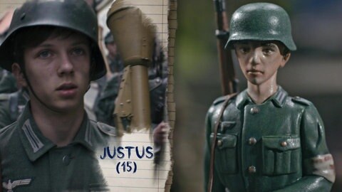 Justus mit Uniform, Helm und Waffe.