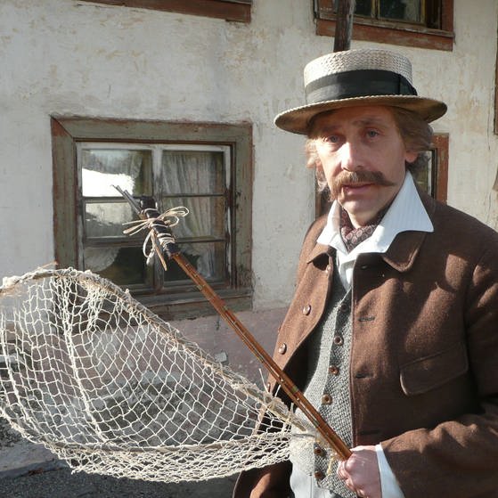 Mann mit Hut vor einem Haus (Foto: Tilmann Büttner)