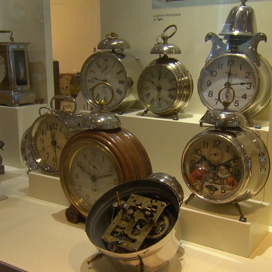 Verschiedene eckige und runde Wecker in Vitrine